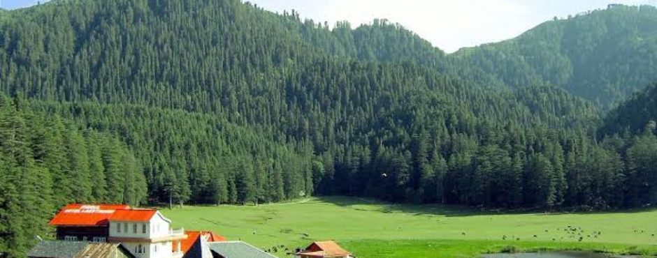 A large, lush green field with a quaint house nestled in the middle, showcasing a tranquil countryside view.