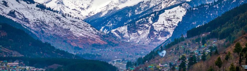 Scenic View Of Mountains covered with snow and settlements at the base